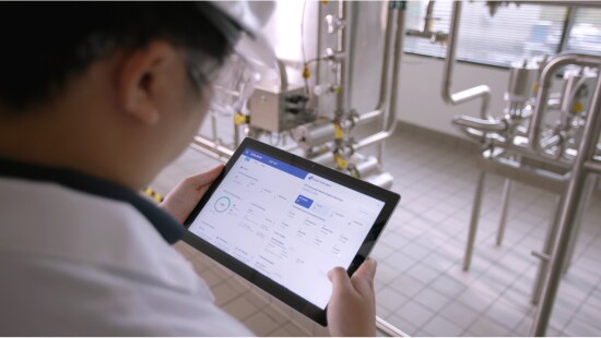 Ecolab expert reviewing data on CIP IQ tablet.